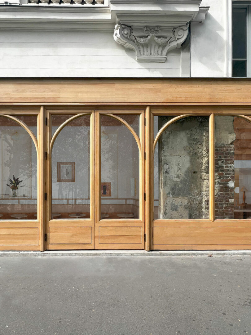 Building facade with arched windows framed in eucalyptus wood.