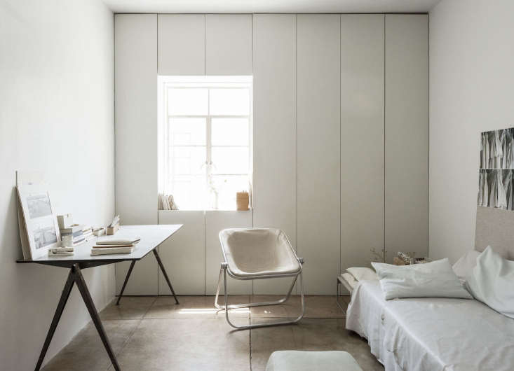 All-white bedroom in Pasadena featuring floor-to-ceiling built-in cabinets surrounding a window.