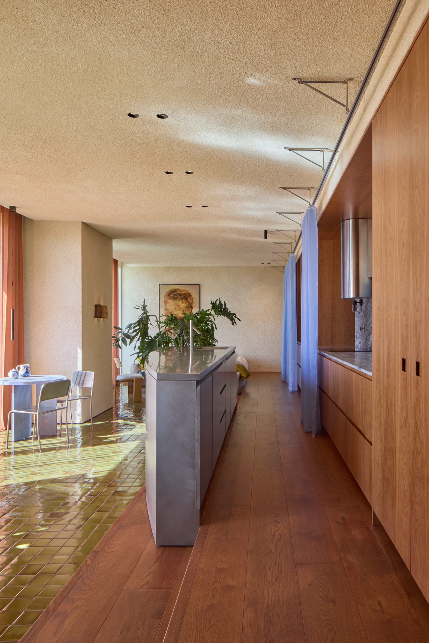 The entrance of the apartment featuring a raised wooden path adjacent to a stone floor.