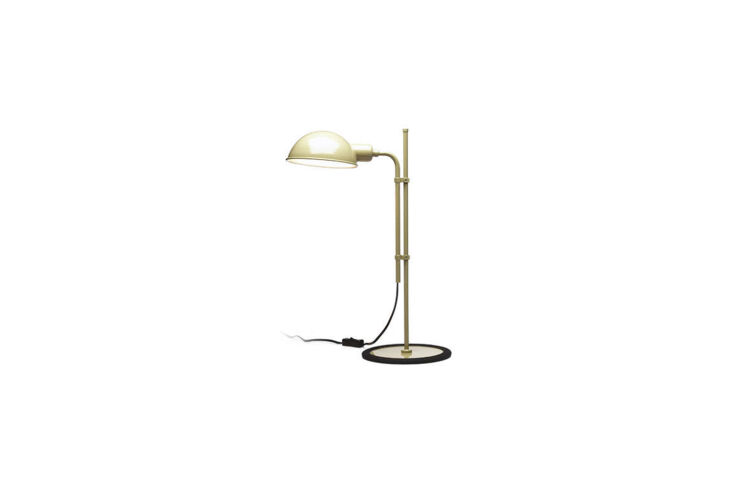 A beige industrial-style table lamp on a minimalist wooden desk.