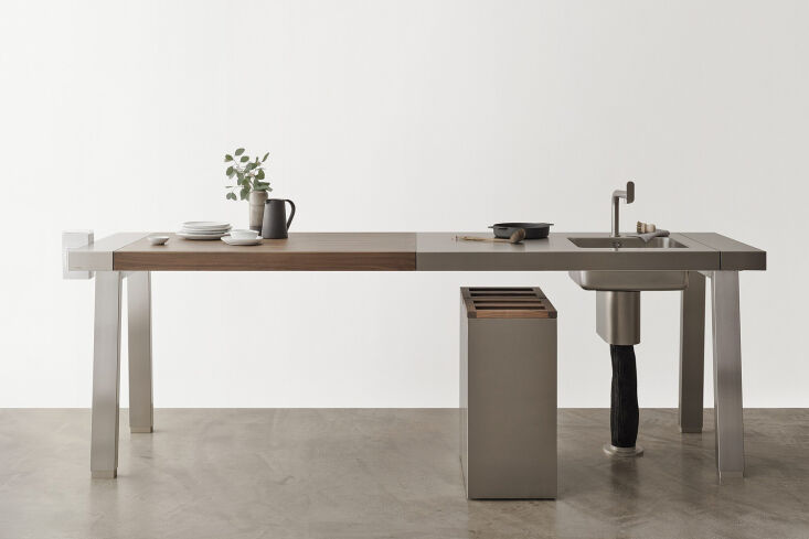 A minimalist Bulthaup b2 workbench featuring a clean wooden surface and integrated sink.