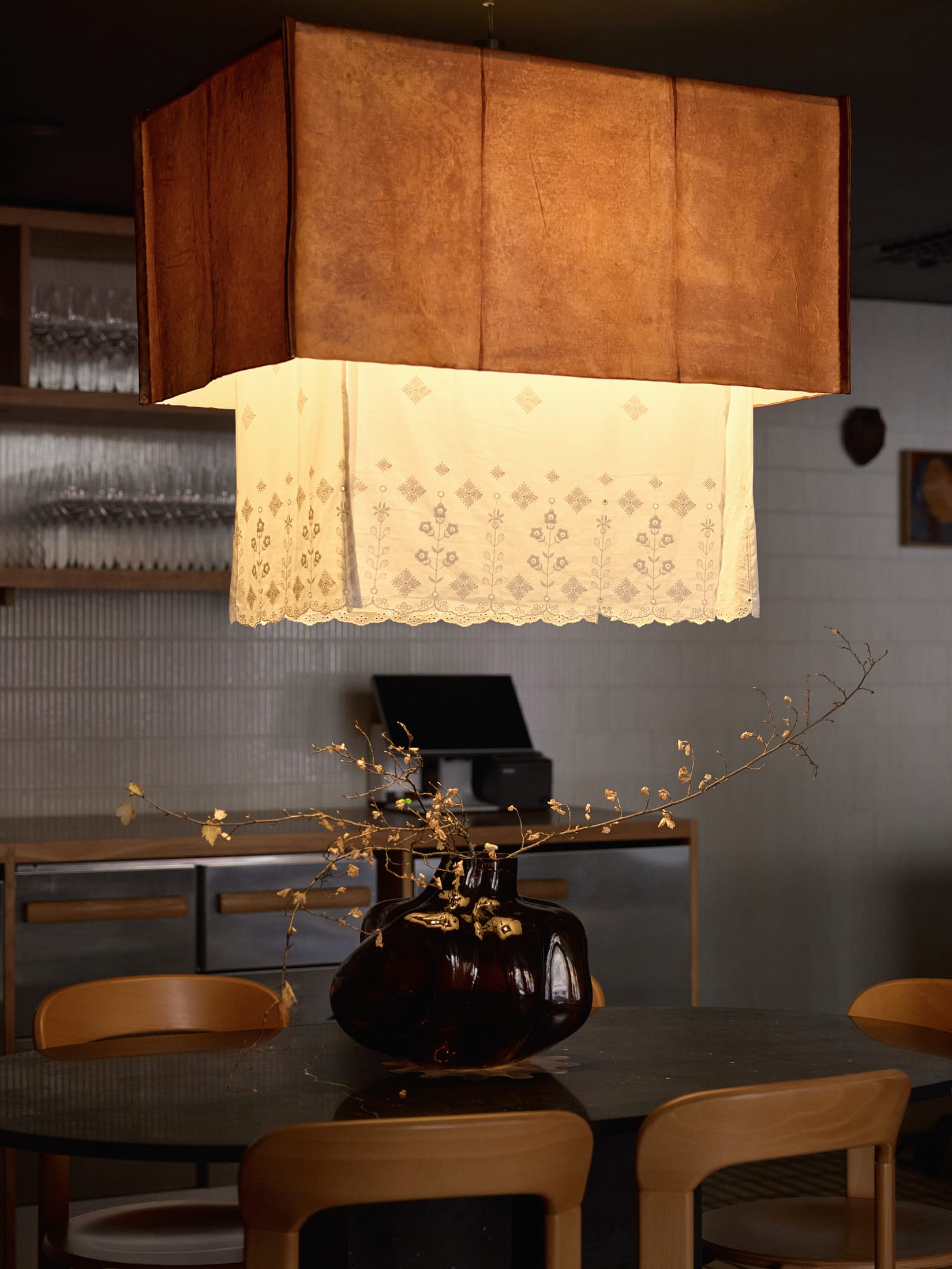 Detail of a wooden column with a distinctive red leather strap and metal handle.