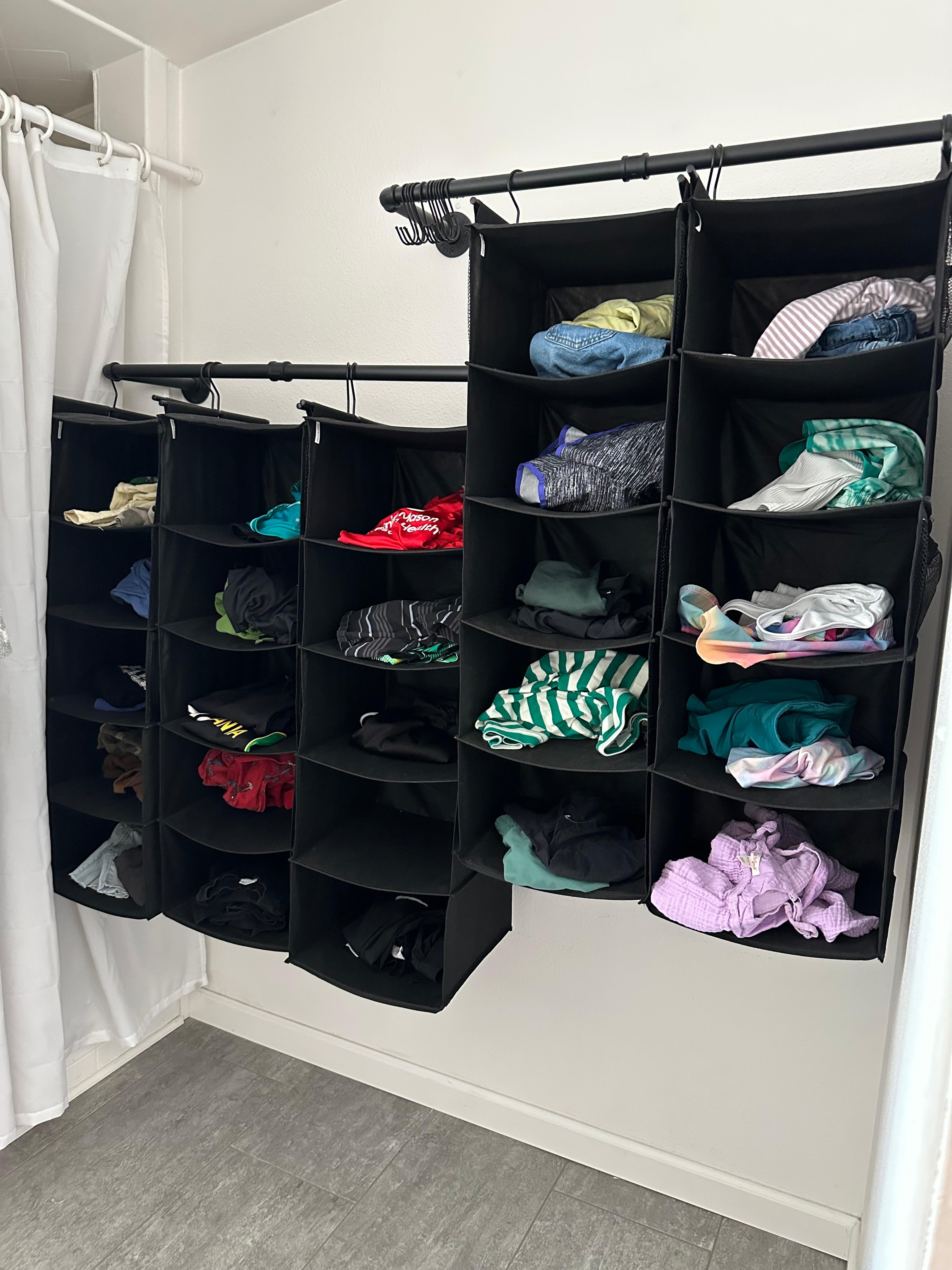 Close-up of neatly folded children's laundry placed inside a vertical shoe organizer cubby.