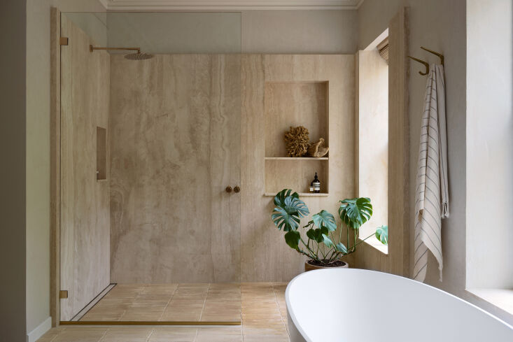 A sophisticated bathroom with a wet room setup in a renovated brownstone.