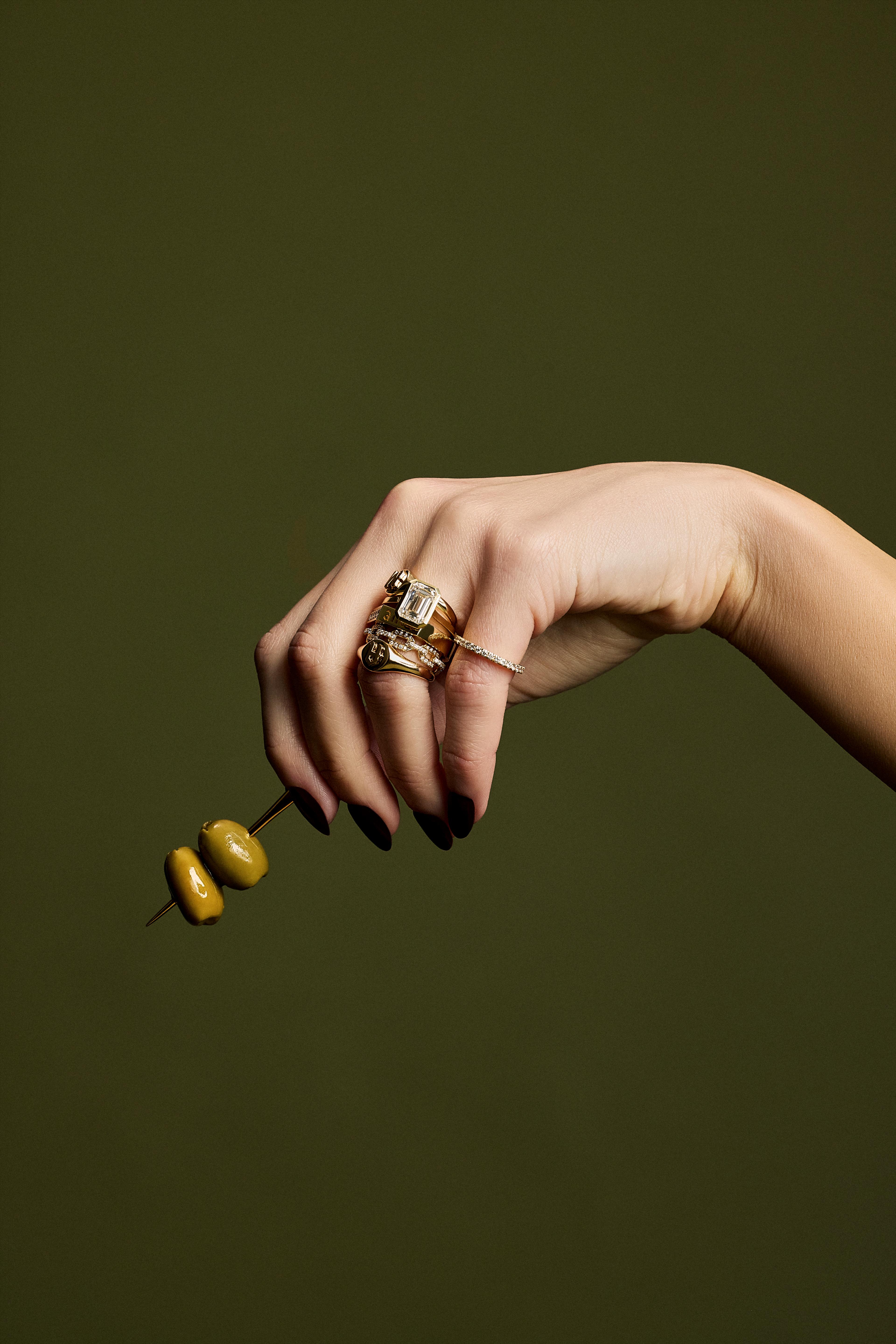 A hand holding the Jennifer Fisher 14k gold toothpick to show scale.