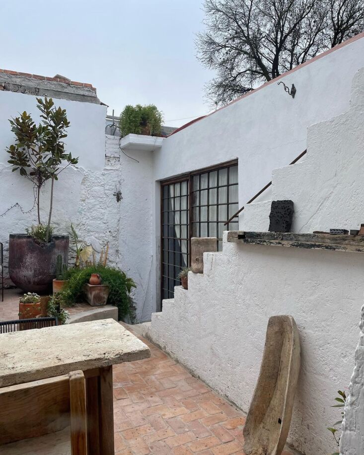 Central courtyard view featuring large steel-framed windows repurposed as sliding glass doors.