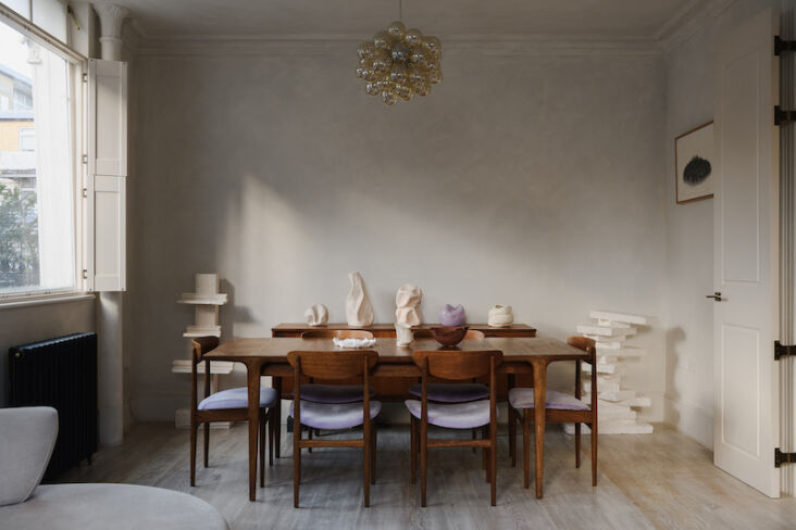 Dining room with lilac-upholstered chairs and a sculptural bubble chandelier.