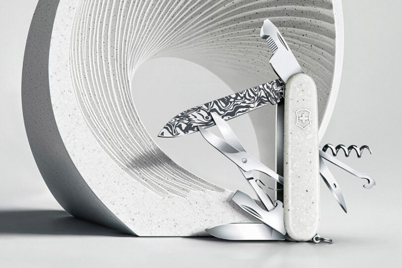 Victorinox knife with tools extended posed in front of a modern white sculpture.