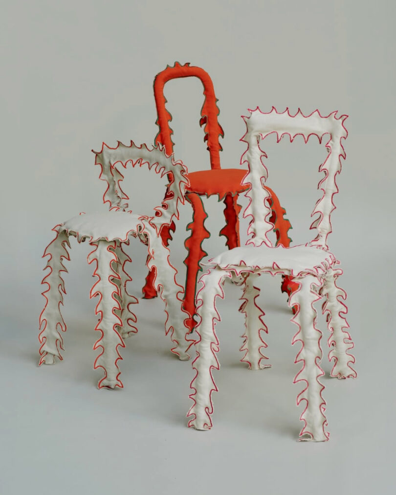 Three chairs with wavy, textured outlines in bright orange and white, resembling 3D-printed or molded sculptures.