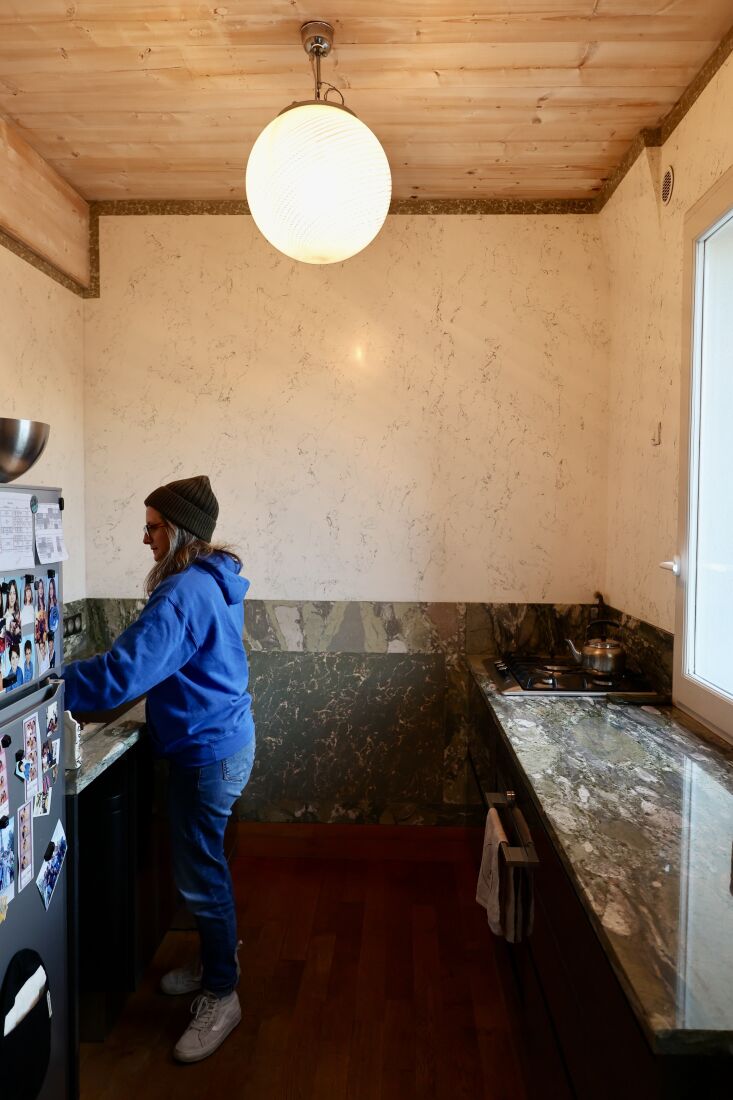 Kitchen interior featuring green-veined granite counters and marble stucco walls.