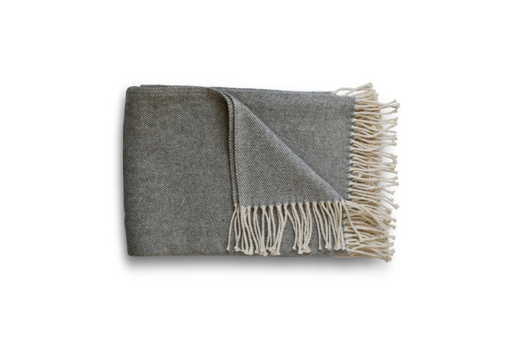 A close-up of a white cotton herringbone weave throw blanket.
