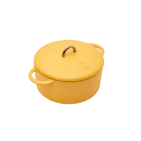 Flat lay of raw black lentils, fennel bulbs, sweet potatoes, and fresh herbs on a wooden countertop.