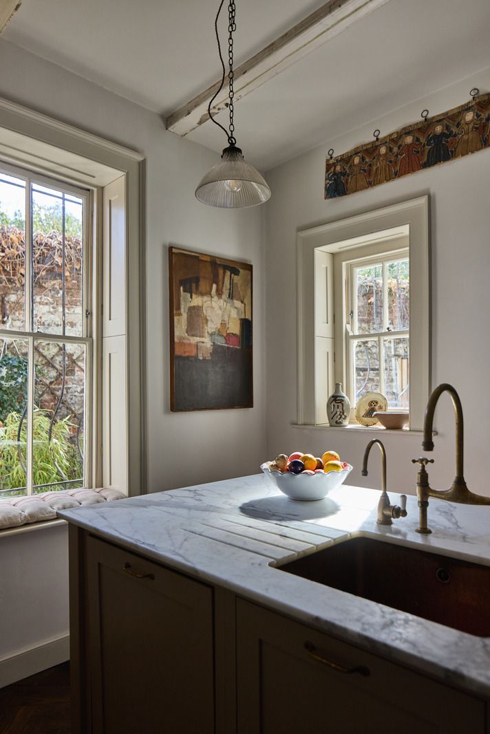A Georgian kitchen in Crooms Hill featuring original 18th-century Delft tiles and blue cabinetry.
