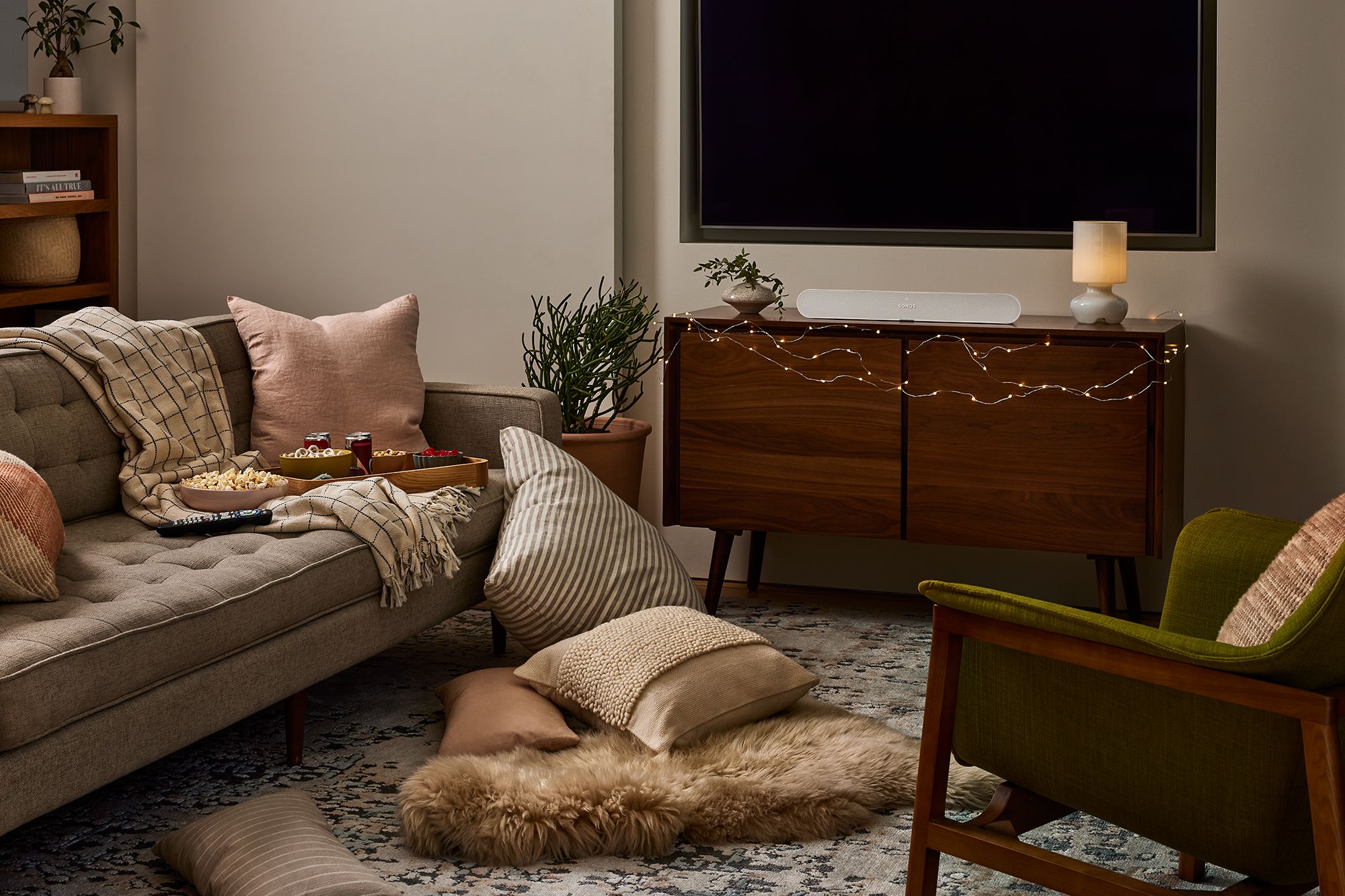 Mid-century modern living room with a tufted sofa, layered textures, and warm ambient lighting.