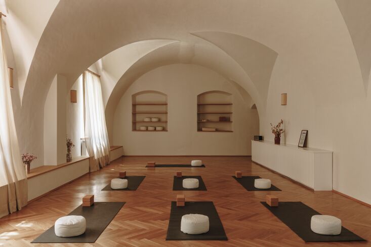Minimalist yoga studio with vaulted ceilings and wooden floors.