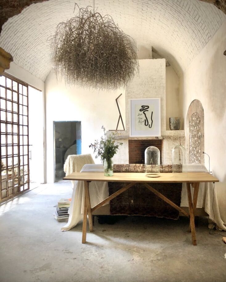 Interior view of a living room with a high, hand-laid brick vaulted ceiling and white walls.