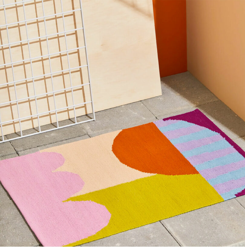 A bathroom rug featuring a vibrant, multi-colored geometric pattern.