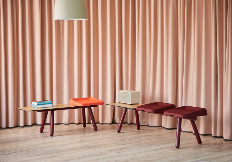 Modular low benches with colorful cushions and wooden legs arranged in a cozy, modern living space.