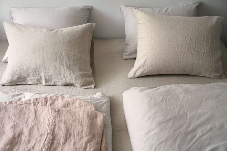 A peaceful bedroom with textured neutral linen bedding and soft lighting.