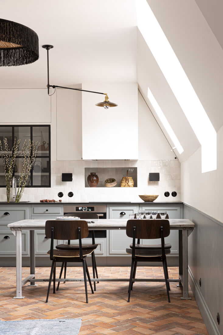 Camouflaged upper storage cabinets recessed into the wall next to a range hood.