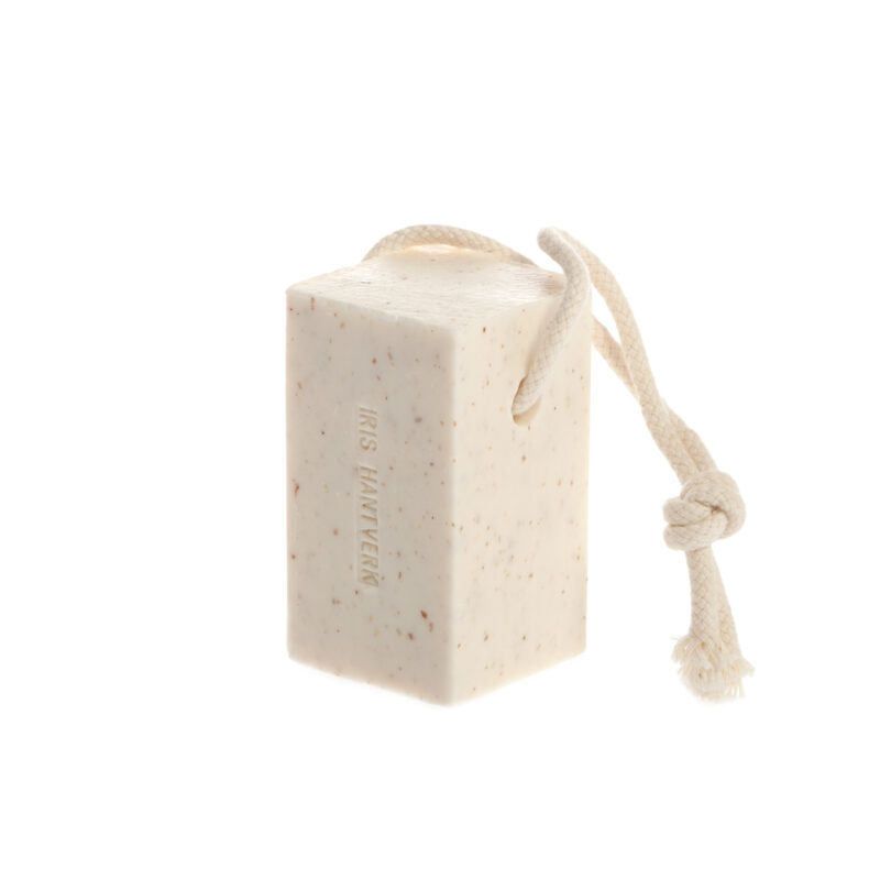 Textured bar of soap with a natural rope loop on a white minimalist background.