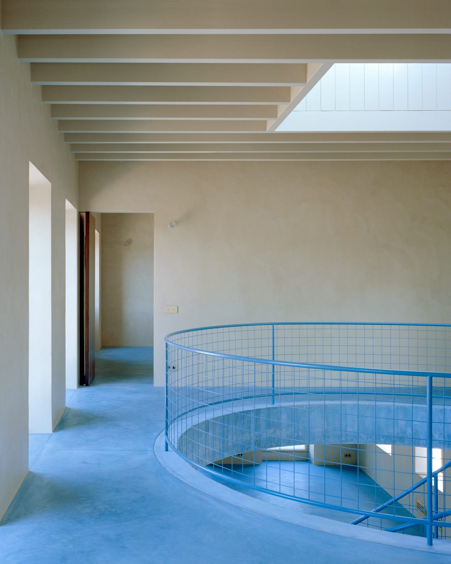 A bathroom space with blue onyx surfaces and matching blue-pigmented concrete walls.