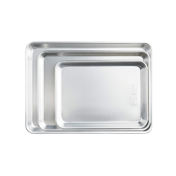 Cubed sweet potatoes roasted to a golden brown with charred edges on a metal sheet pan.