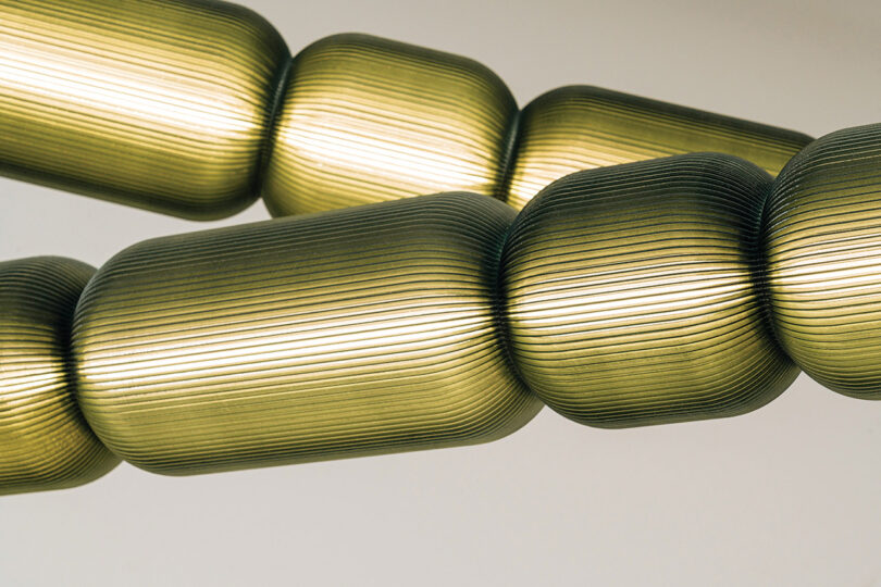 Close-up of segmented capsule-shaped pendant lights with a warm interior glow.