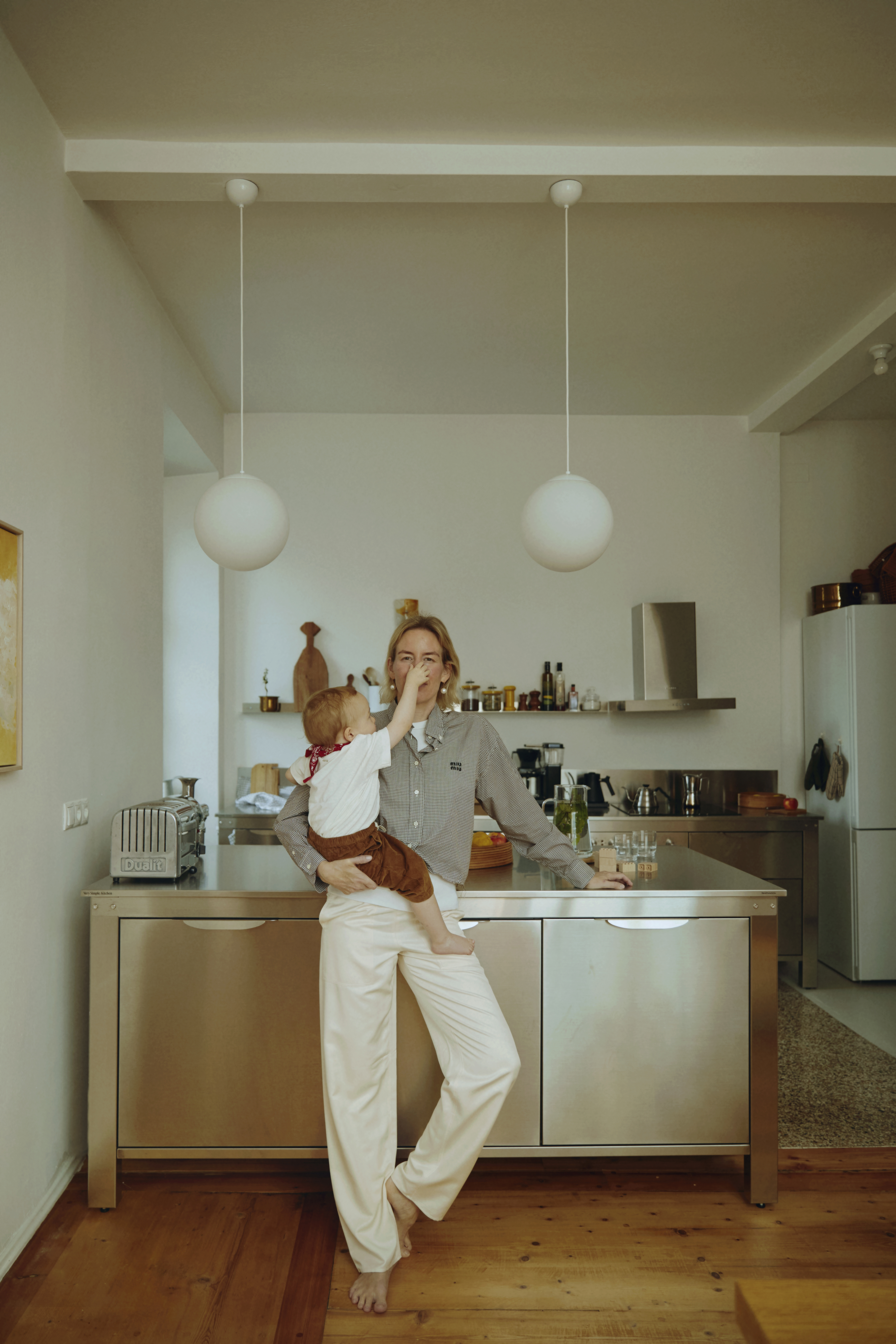 A woman and her child in an open-plan kitchen area emphasizing the social connection between cooking and dining zones.