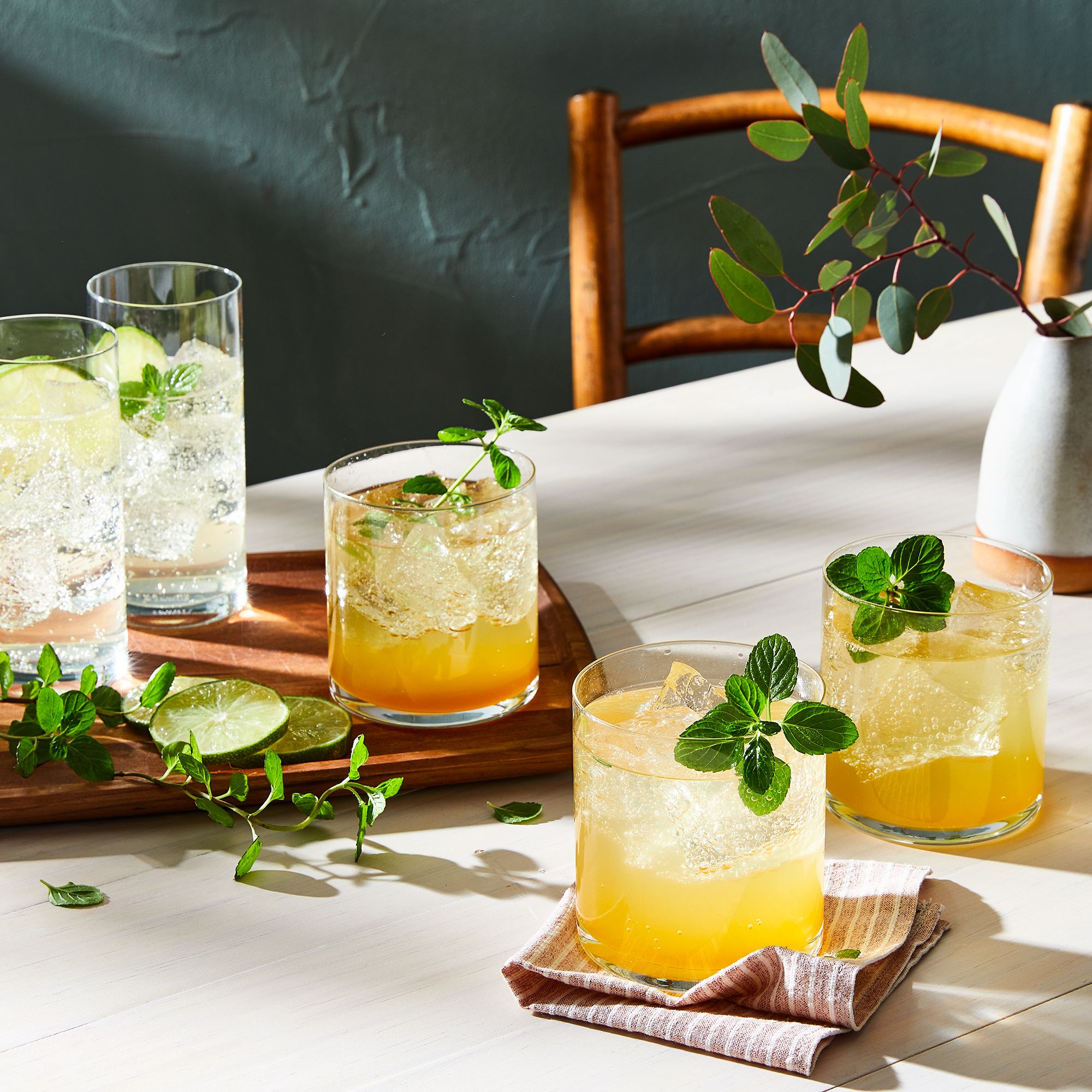 A bright and inviting setup showing the ingredients and process for creating tea-infused cocktails at home.