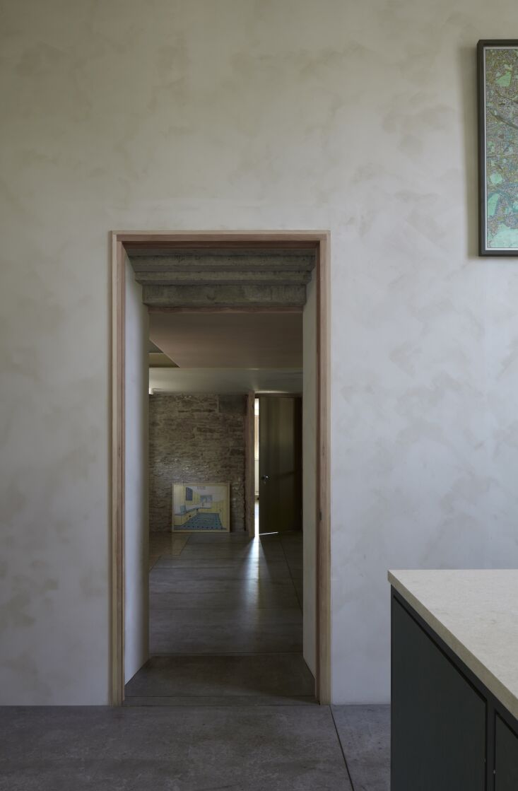 Interior view of a modern atrium and staircase with walls finished in soft white clay paint.