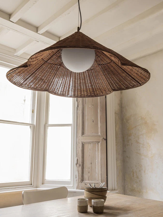 Oversized scalloped rattan pendant light hanging in a rustic-chic kitchen.