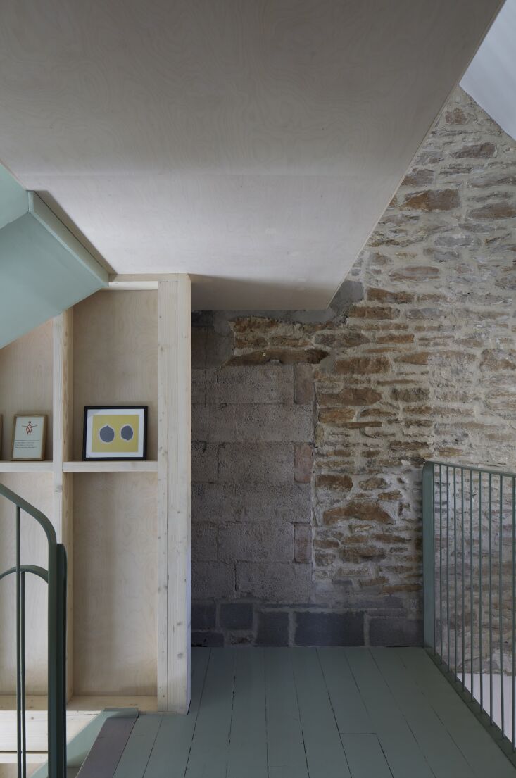 Close-up of a stone wall being treated with lime and cork-based insulating plaster for improved thermal performance.