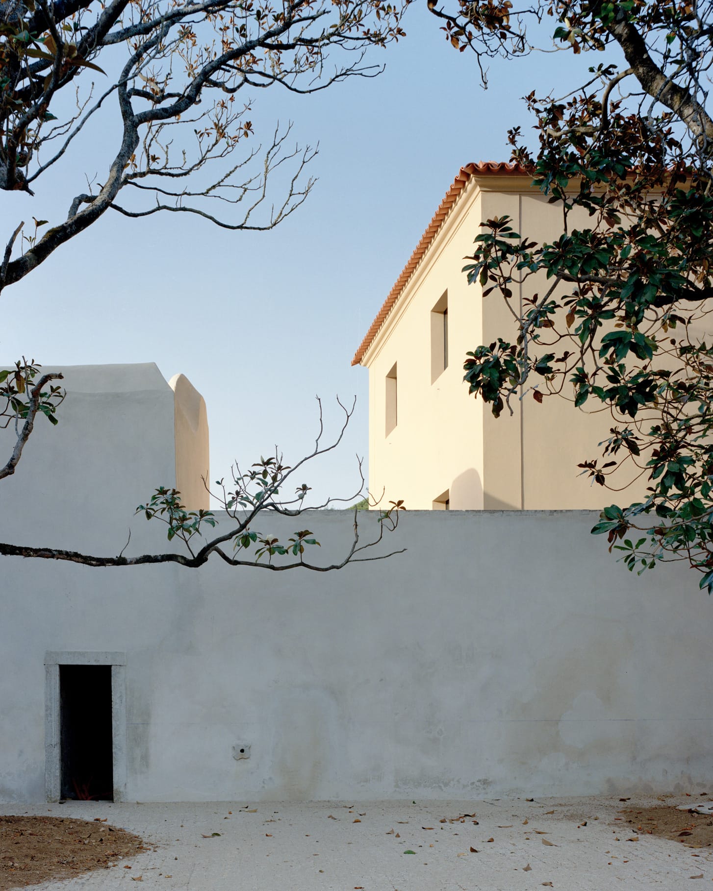 Wide interior shot of House II showing the blue concrete structure and stone walls.