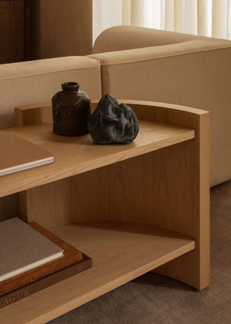 Detailed view of light oak shelving unit with minimalist sculptural decor.