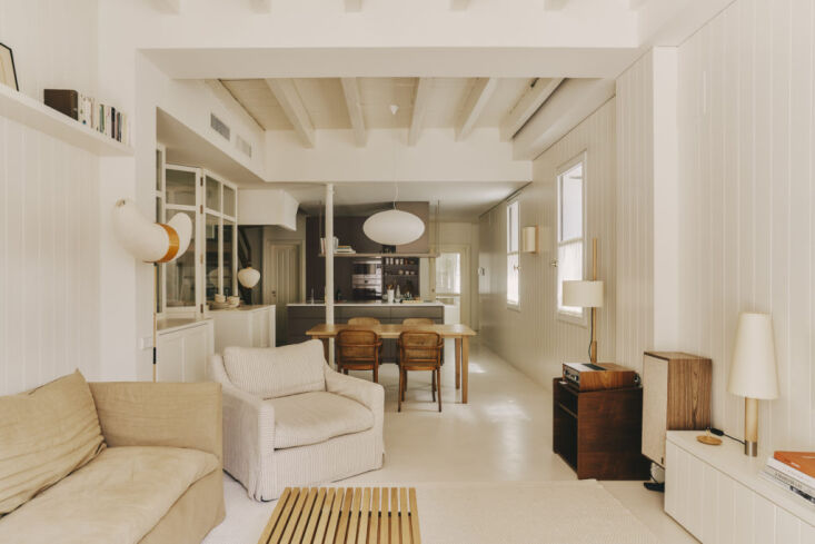 A Básica lamp on a long wooden credenza in an open-plan living room.