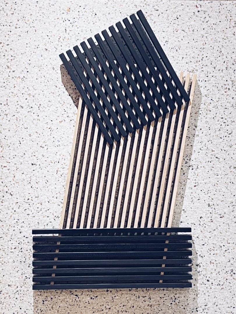 Abstract sculptural wooden slat installation in black and natural tones.