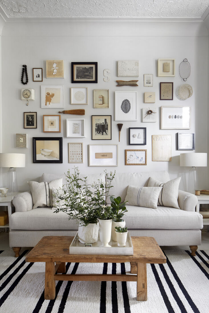 A gallery wall featuring a dense collection of art, photos, and textiles.