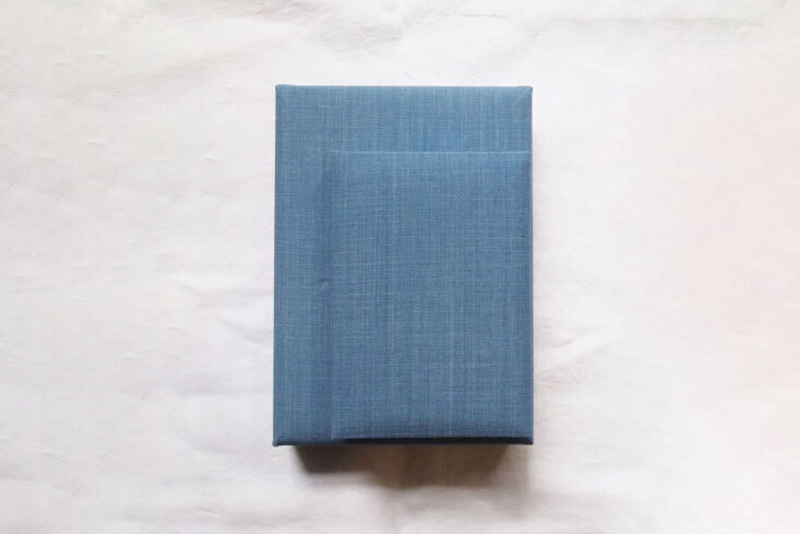 Handmade light indigo cotton-covered boxes stacked neatly.