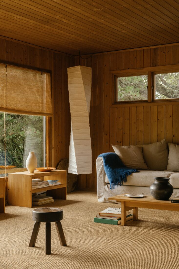 A corner of the house featuring a Noguchi Akari ceiling lamp, a pine stool, and a blue wool blanket.
