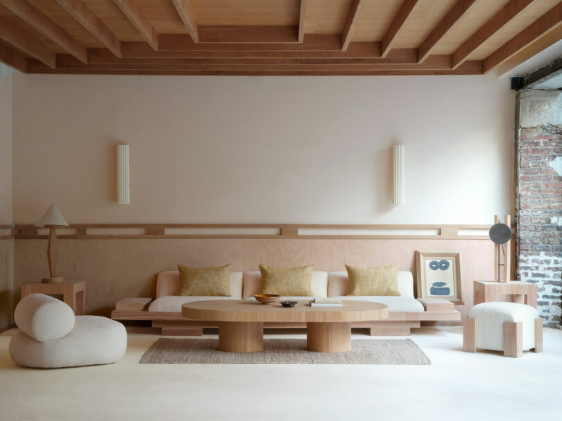 Living room with a low eucalyptus sofa, round chairs, and a matching wooden ceiling.