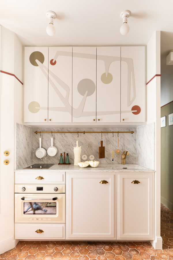 A compact Parisian kitchen with a mini induction hob and small sink in a 16-square-meter studio.