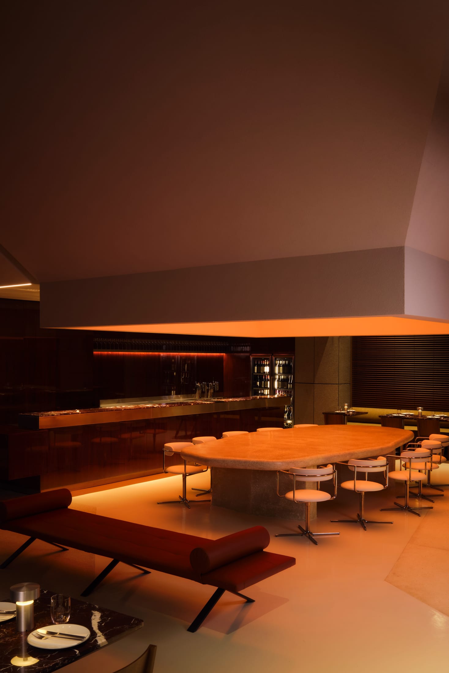 A minimalist dining corner featuring a custom-designed sculptural floor lamp with a glowing sphere.