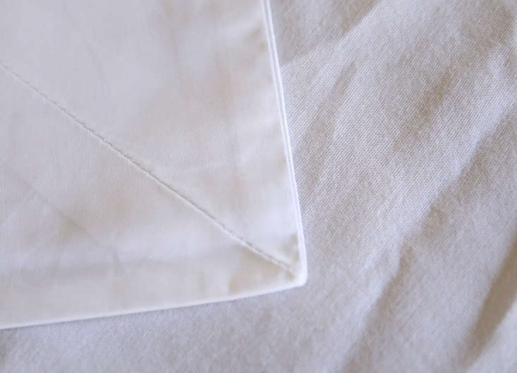 Macro shot comparing Sferra's fine weave on top with budget sheets on the bottom.