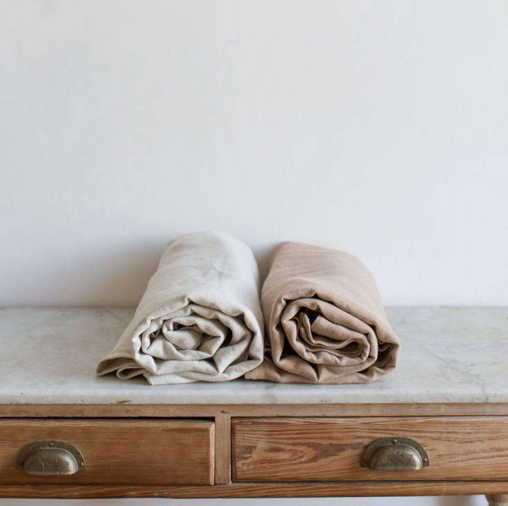 Layered Belgian linen bedding in ivory and taupe tones on a contemporary bed.