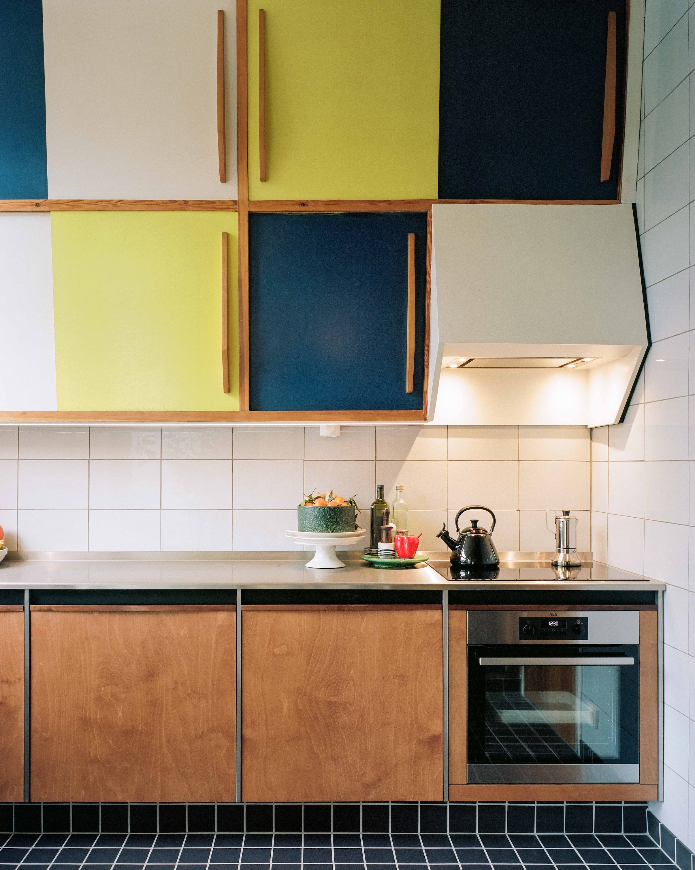 Detail of new birch plywood lower cabinets with tiled toe kicks that match the floor.