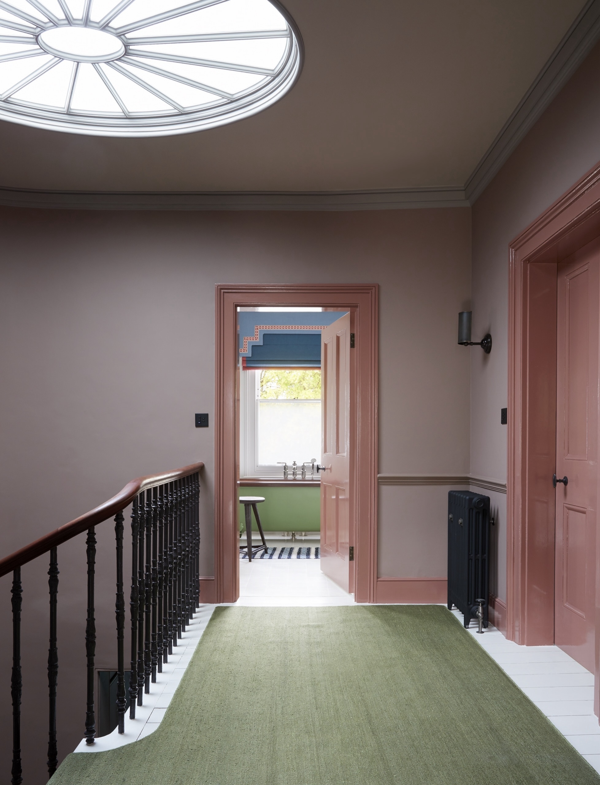 An upstairs hallway featuring mauve walls and darker rose-colored doors and trim.