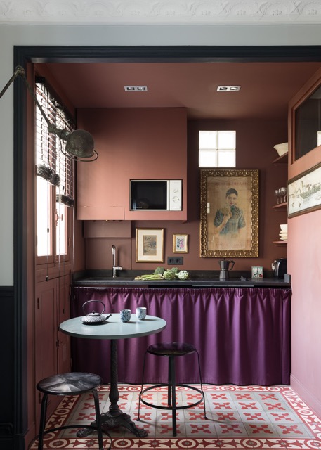 A kitchen painted entirely in deep Pompeian Brown with a black architectural frame.