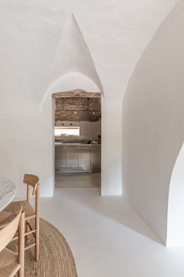Interior view showing seamless microcement floors and original stone doorway frames.
