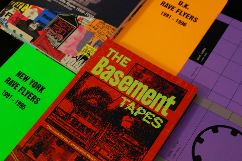 Close-up of various music and rave culture booklets and books arranged on a table.